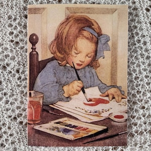 Schilderij. Luxe wenskaart. Jessie Willcox Smith-kunstenaar. Een klein meisje schildert foto's aan het bureau. Kaart in vintage-stijl. 7 x 5 inch.