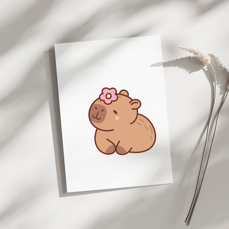 May include: A cute cartoon illustration of a brown capybara wearing a pink flower on its head. The capybara is sitting with its legs crossed and has a happy expression on its face.