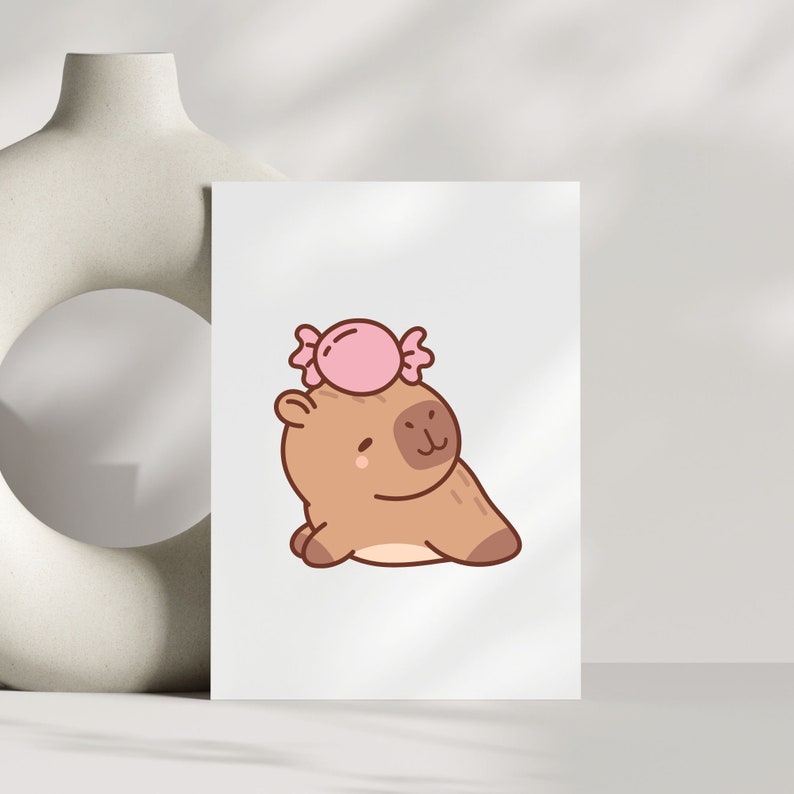 May include: A brown cartoon capybara with a pink candy on its head. The capybara is sitting on its hind legs with its front paws in front of it.
