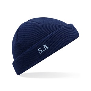 May include: A navy blue beanie with a light blue embroidered "S.A." on the front.