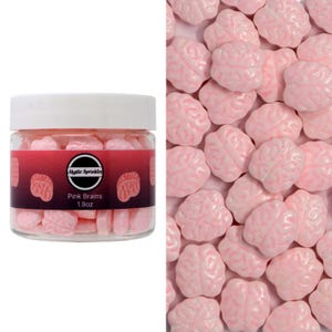 Puede incluir: Un frasco transparente lleno de sprinkles rosas con forma de cerebro. El frasco tiene una tapa blanca y una etiqueta que dice "Mystic Sprinkles Pink Brains 1.9oz".