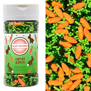 Op de afbeelding: Een doorzichtige plastic container met Mystic Sprinkles "Carrot Patch" strooiselmix. De mix bevat oranje wortelvormige sprinkles, groene staafvormige sprinkles en bruine sprinkles. Het etiket van de container heeft een groene achtergrond met wortel- en konijnenillustraties.