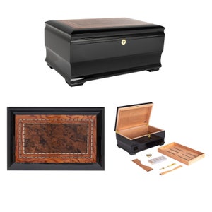 May include: A black wooden humidor with a brown wood inlay and a brass lock. The humidor is open and shows a cedar lining and a removable tray. The humidor comes with a humidifier, a hygrometer, and a cedar divider.