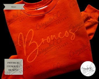 May include: Orange sweatshirt with the word "Broncos" in a white, cursive font.