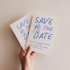 May include: Two white "Save the Date" cards with blue handwritten text and illustrations. The cards announce a wedding with the names Sarah and Kyle, the date November 5th, 2026, and the location in Tampa.