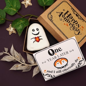 Regalo peculiar para el primer aniversario con una roca pintada con un abrazo fantasmal espeluznante y tierno, una historia de amor romántica oscura y una tarjeta de aniversario con la frase "Todavía lo hago" para mi esposo