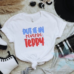 May include: White t-shirt with the text "Put it in reverse Terry" in blue and red lettering with stars around the text.