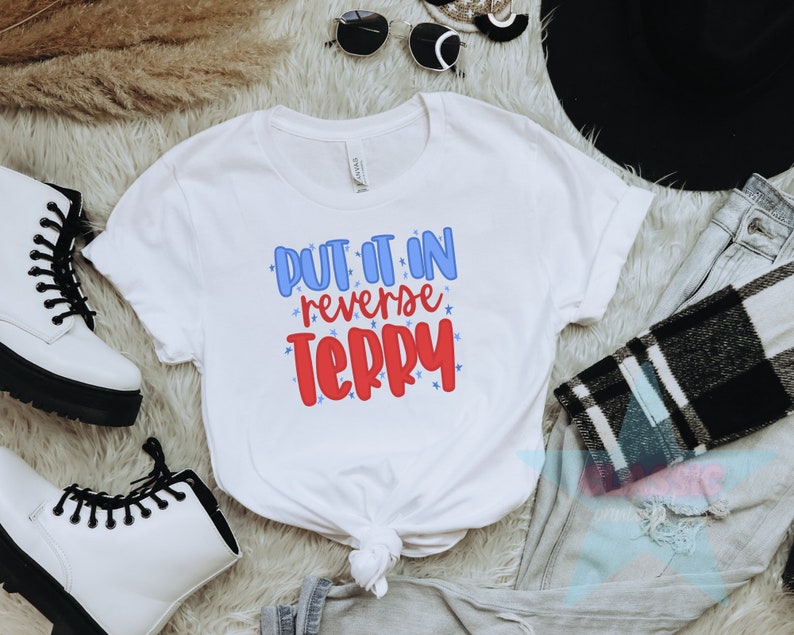 May include: White t-shirt with the text "Put it in reverse Terry" in blue and red lettering with stars around the text.