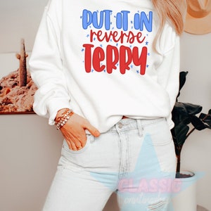 May include: White sweatshirt with the text "Put it in reverse Terry" in red and blue lettering with stars around the text.