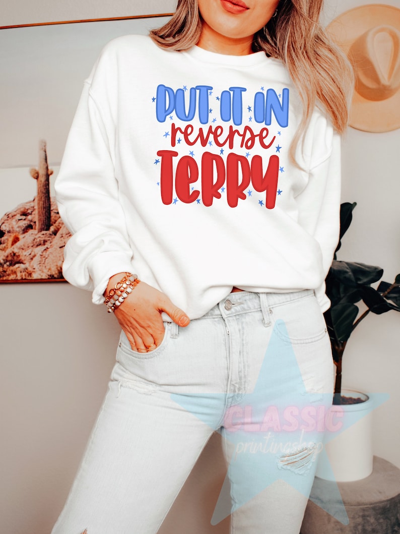 May include: White sweatshirt with the text "Put it in reverse Terry" in red and blue lettering with stars around the text.