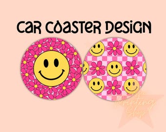 Puede incluir: Dos posavasos para coche a cuadros rosa y blancos con una cara sonriente y flores rosas. Los posavasos son redondos y tienen un borde blanco.