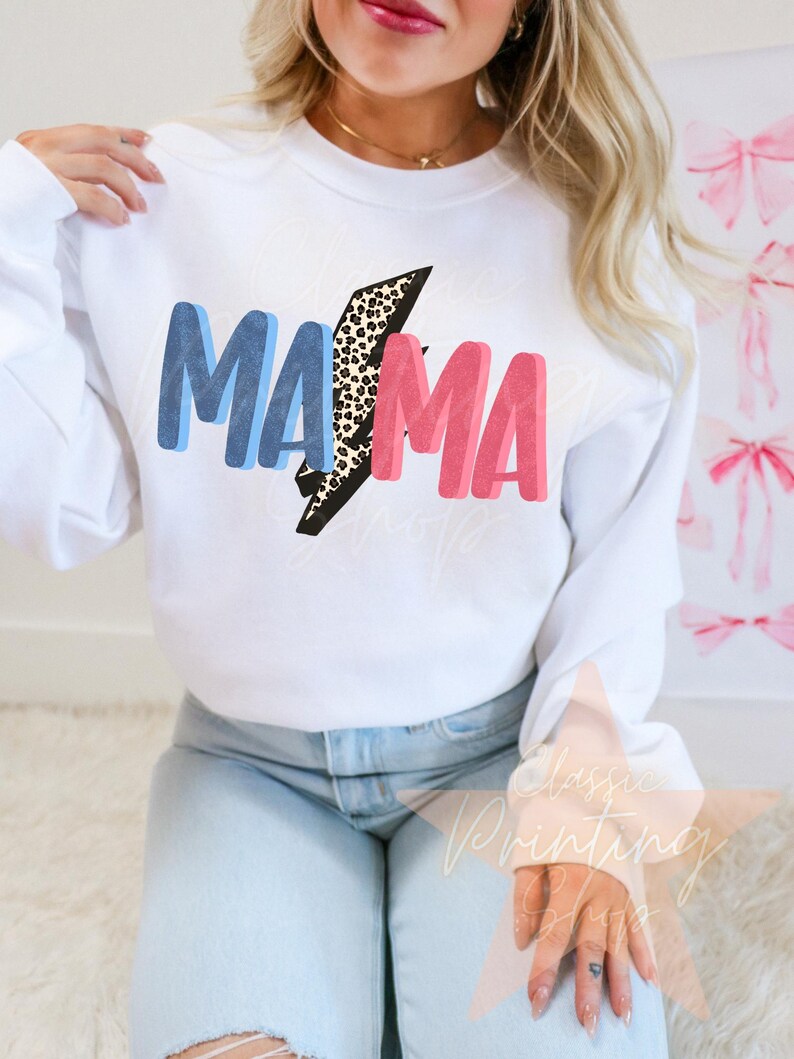 May include: White sweatshirt with the word "MAMA" in blue and pink letters with a leopard print lightning bolt in between the words.