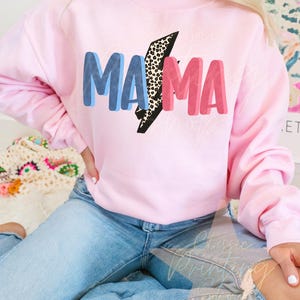 May include: A pink sweatshirt with the word "MAMA" in blue, pink, and black letters with a leopard print lightning bolt design.