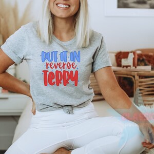 May include: A gray t-shirt with the text "Put it in reverse Terry" in red and blue lettering.