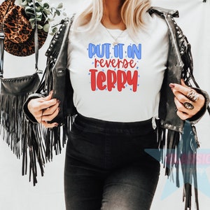 May include: White t-shirt with the text "Put it in reverse Terry" in red and blue lettering with stars.
