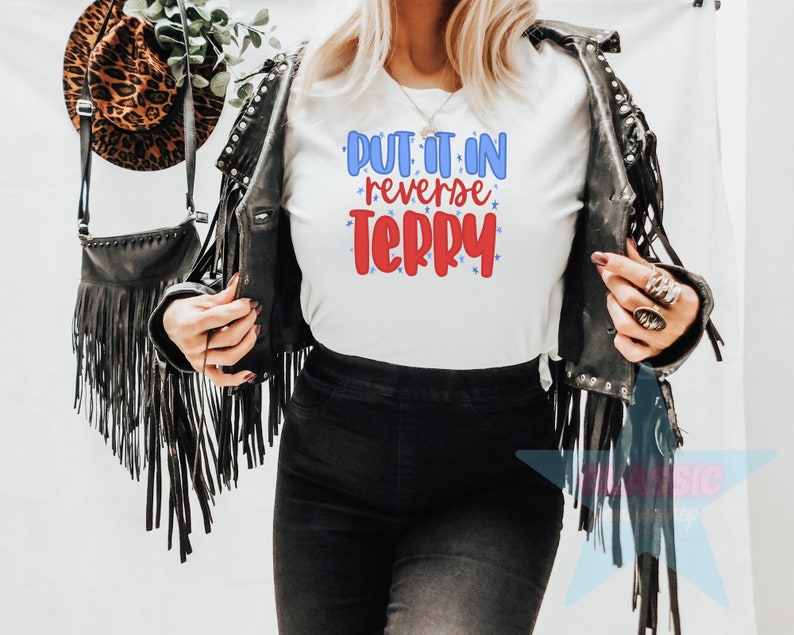 May include: White t-shirt with the text "Put it in reverse Terry" in red and blue lettering with stars.
