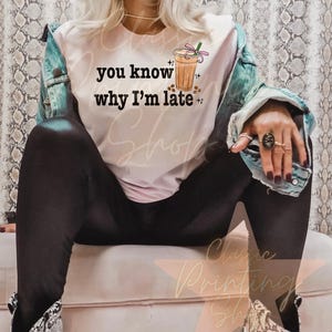 Puede incluir: Una camiseta blanca con el texto "you know why I'm late" y una imagen de dibujos animados de una bebida de caf&eacute; helado con una pajita rosa y espolvoreos.