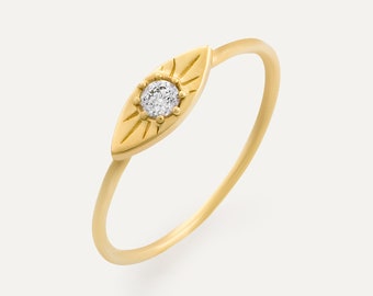 May include: A gold ring with a small diamond set in an eye-shaped design. The eye is surrounded by a sunburst pattern.