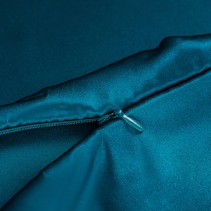 May include: A teal blue satin pillowcase with a zipper closure.