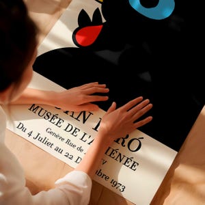 May include: A poster featuring a black abstract design with red, blue, and yellow accents. The poster includes text in French: "MUS&Eacute;E DE L'A I&Eacute;N&Eacute;E, AN I R&Oacute;, Du 4 Juliet au 22 D, Gen&egrave;ve Rue de, V, abre 1973."