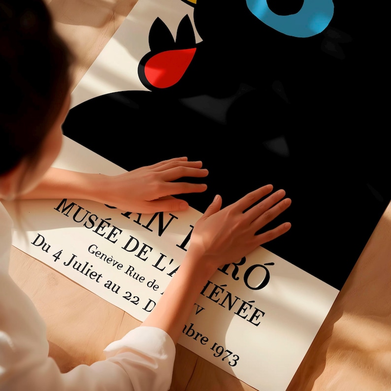 May include: A poster featuring a black abstract design with red, blue, and yellow accents. The poster includes text in French: "MUS&Eacute;E DE L'A I&Eacute;N&Eacute;E, AN I R&Oacute;, Du 4 Juliet au 22 D, Gen&egrave;ve Rue de, V, abre 1973."
