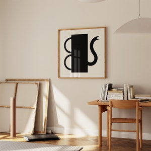 Può includere: Una stampa d'arte astratta in bianco e nero di una forma geometrica con una coda curva, incorniciata in una cornice in legno naturale.
