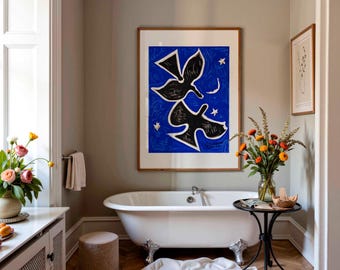 May include: A framed wall art print featuring two black stylized birds against a vibrant blue background with a small white crescent moon and stars, displayed above a white clawfoot bathtub in a room with light gray walls and herringbone floors.