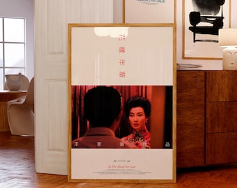 Puede incluir: Un póster de película enmarcado de In The Mood For Love con una imagen central de dos personas en un entorno de tonos cálidos. El póster incluye caracteres chinos rojos verticales en la parte superior, texto en la parte inferior y un marco de madera clara.