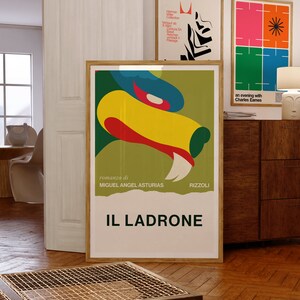 May include: A vintage poster for the novel "Il Ladrone" by Miguel Angel Asturias. The poster features a colorful abstract illustration of a creature with sharp teeth and a green, yellow, red, and blue color scheme. The text "romanzo di" and "RIZZOLI" are also visible on the poster.