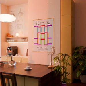May include: A framed art print with a colorful geometric design by Max Bill hangs on a wall. The artwork features vertical and horizontal lines in various colors. A brass trumpet and a potted plant are also visible.