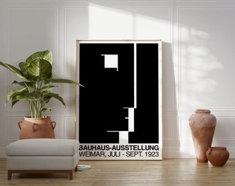 Peut inclure: Affiche d'art géométrique noir et blanc avec le texte "BAUHAUS-AUSSTELLUNG WEIMAR, JULI - SEPT. 1923". L'affiche est encadrée et accrochée à un mur blanc.