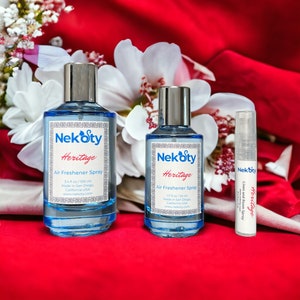 May include: Three glass bottles of air freshener spray in different sizes. The bottles are blue and have a silver cap. The labels are white with black text and say "Nekoty Heritage Air Freshener Spray". The smallest bottle says "Linen and Room Spray".