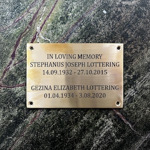 Puede incluir: Una placa conmemorativa rectangular de lat&oacute;n con cuatro orificios para tornillos en las esquinas, grabada con el texto: IN LOVING MEMORY, STEPHANUS JOSEPH LOTTERING 14.09.1932 - 27.10.2015, GEZINA ELIZABETH LOTTERING 01.04.1934 - 3.08.2020 en letras negras.