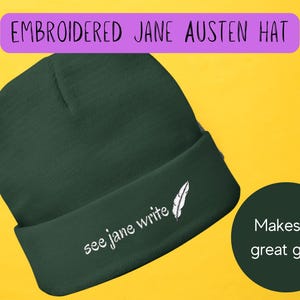 May include: A dark green beanie with a white embroidered feather and the text "see jane write".
