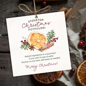 May include: A white card with the text "STOVETOP Christmas POTPOURRI" and instructions for making potpourri. The card features a watercolor illustration of a dried orange slice, cinnamon sticks, and berries. The card is tied with twine.