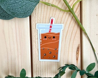 May include: A brown and white cartoon illustration of a cup of boba tea with a red and white straw. The boba tea has a smiling face and is surrounded by brown boba pearls.