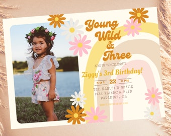 May include: A custom invitation for a third birthday party. The design features a photo of a young child wearing a floral crown, daisies, a rainbow, and the text "Young Wild & Three". The invitation includes the date, time, and location.