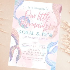 Può includere: Un invito rosa pastello con illustrazioni di code di sirena nei toni del blu, viola e rosa. Il testo recita "Let's Shellabrate Our Little Mermaids!" e include i dettagli della festa di compleanno di Koral e Remi.