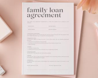 May include: A light pink family loan agreement form with the title "family loan agreement" in a bold, gray font. The form includes sections for lender and borrower information, loan terms, and signatures. The form is on a stack of pink paper.
