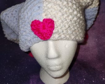 May include: A white and light blue crocheted hat with a pink heart on the side. The hat is on a white mannequin head.