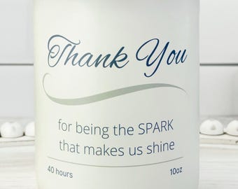 May include: White candle with a wooden lid, featuring the text "Thank You" in script. The candle also has the text "for being the SPARK that makes us shine" and is labeled as 10oz and 40 hours.