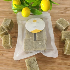 Könnte beinhalten: Eine durchsichtige Plastiktüte gefüllt mit grünen und weißen Zucker-Peeling-Würfeln. Die Tüte ist mit "Envibodycare Lemon & Honey Sugar Scrub Cubes" beschriftet.