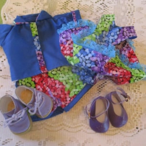 May include: A doll's outfit featuring a blue jacket with floral trim, a matching floral skirt, and two pairs of shoes. One pair is lavender with laces, and the other is purple with straps. The skirt has a blue lace trim.