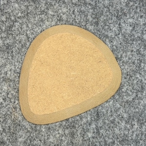 Könnte beinhalten: Eine flache, unregelmäßig geformte Schale aus Kork in hellbrauner Farbe.