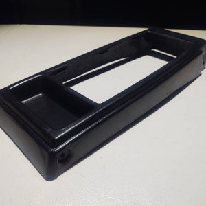 May include: Black plastic car center console storage compartment with a small tray.