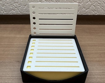 Könnte beinhalten: Eine schwarze Fliegenfischbox mit einem weißen Schaumstoffeinsatz und einem weißen Deckel mit einem Gittermuster. Der Deckel ist geöffnet und der Schaumstoffeinsatz ist sichtbar.