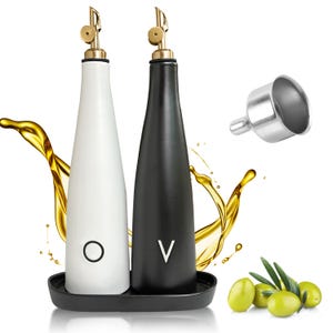 May include: A set of two ceramic oil and vinegar dispensers, one white with a circle and one black with a "V", on a black tray. Each bottle has a gold-colored spout. A silver funnel and olives are also present.