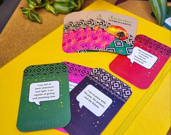 May include: A set of affirmation cards with colourful geometric patterns and inspirational messages. The cards feature a speech bubble design and the text "Ascension Affirmations".