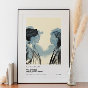 May include: A framed art print featuring a stylized illustration of two women facing each other. The artwork is in shades of blue and gray, with text that reads "I would, wouldn't you?" and "AVA DANIELS". The print is displayed on a wooden cabinet.