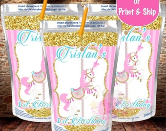 Puede incluir: Una bolsa de jugo rosa y dorada con un diseño de caballo de carrusel. La bolsa tiene el texto "Tristan's 1st Birthday". La bolsa es de 200 ml.